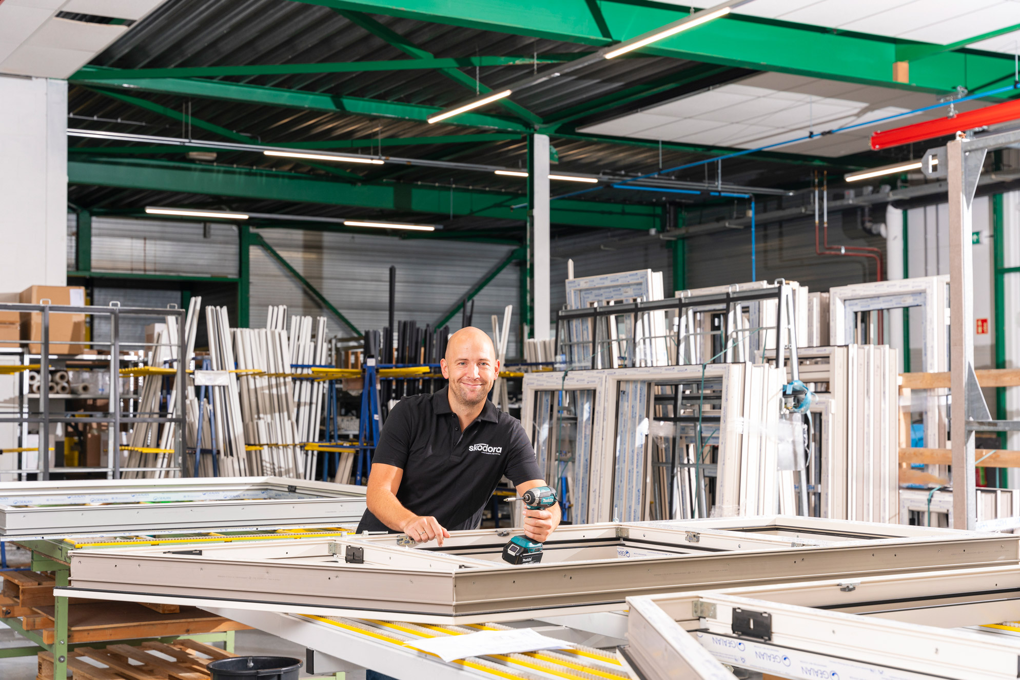 Chris in kunststof kozijnen fabriek met boor