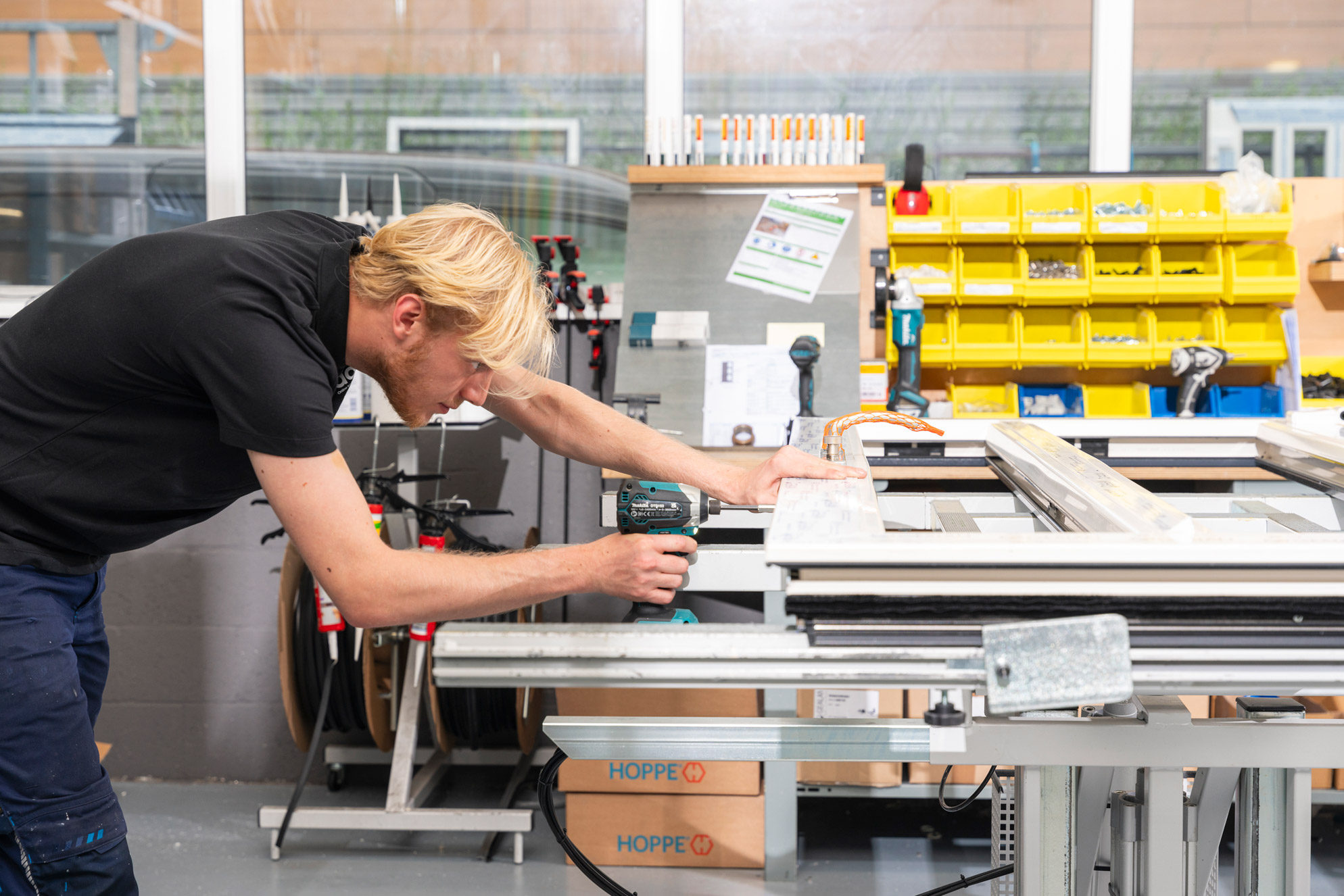 Kunststof kozijnen fabriek collega Jens boort in kozijn
