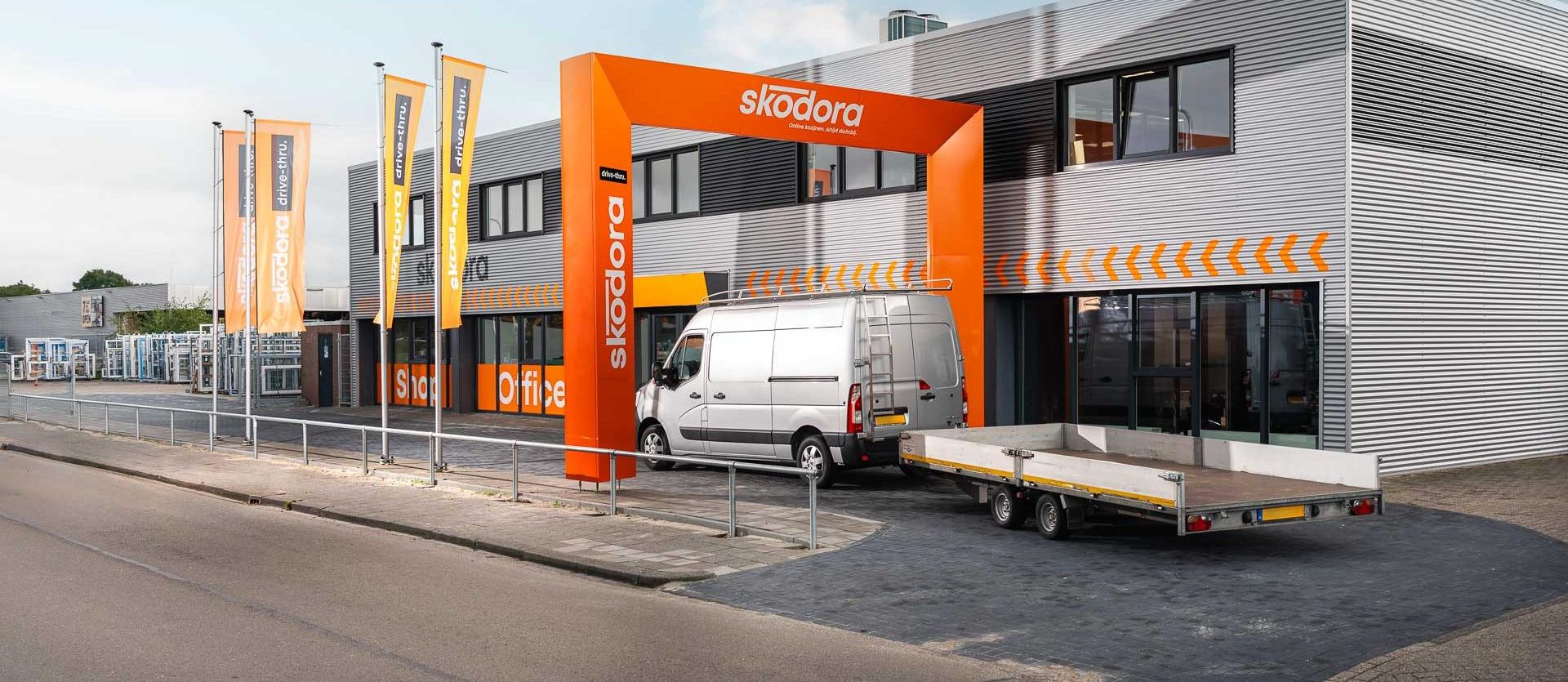 Skodora-drive-thru bus met aanhanger rijdt binnen