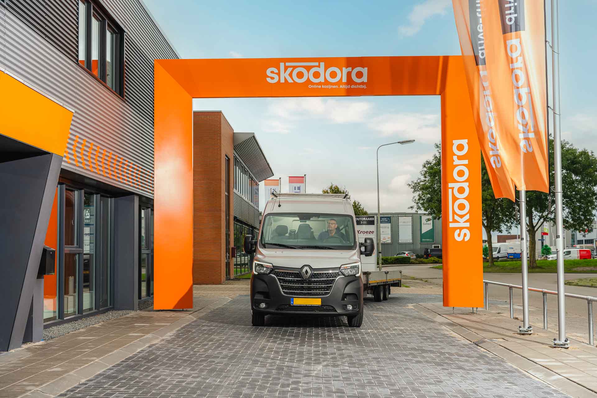 Klant rijdt door drive-thru onder boog