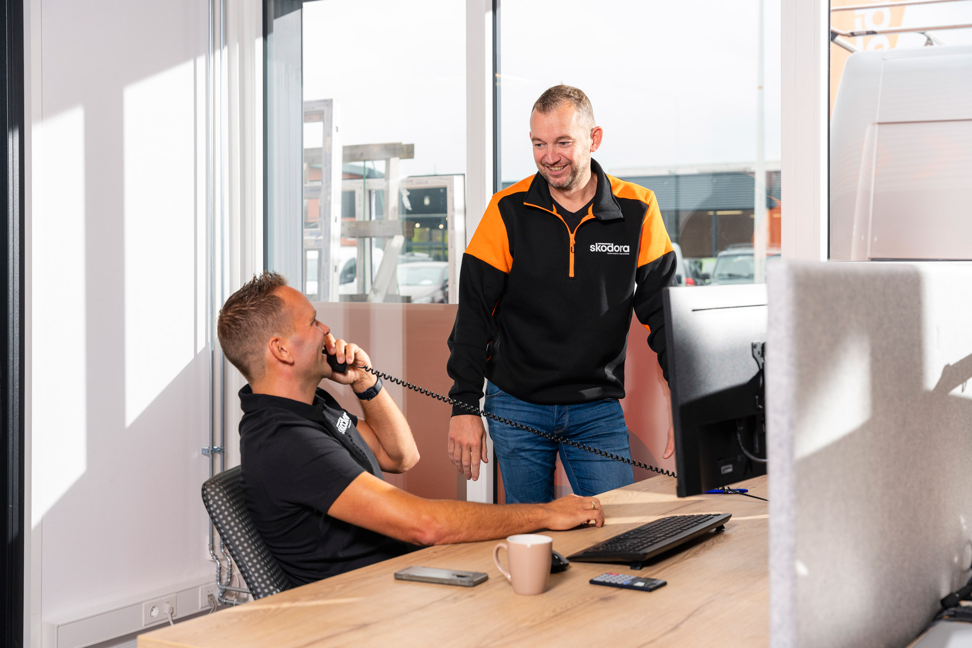 Philip op kantoor aan telefoon met Wietze ernaast
